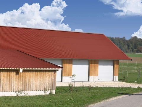 Robuste, rote Dachprofilplatten, bekannt für Umweltverträglichkeit und harmonische Anpassung an ländliche Bauten