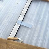 Dach Reparaturband, graues EPDM-Band wird mit einer Andrückrolle auf einer Lichtplatte befestigt