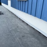 Dach Reparaturband mit MicroSealant, weiße Abdichtung an der Wand eines blauen Hauses