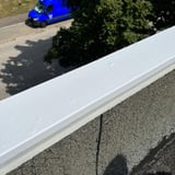 Dach Reparaturband weiß an einer Dachkante, Blick auf eine Straße mit blauem Lieferwagen