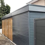 Dachrandprofil ISOS anthrazitgrau an einem Schuppen mit Holz- und Metallverkleidung