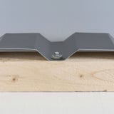 Fertig montierte Edelstahlschraube in der Tiefsicke eines anthrazitgrauen Trapezblechs auf Holz