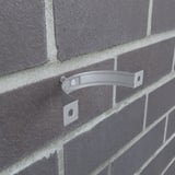 Fallrohrschelle in Graualuminium an einer Ziegelwand montiert, ohne Fallrohr