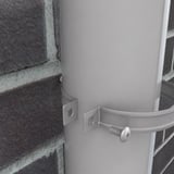 Detailansicht einer Fallrohrschelle in Graualuminium, die ein Fallrohr an einer Ziegelwand haelt
