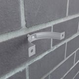 Fallrohrschelle aus Stahl in Weißaluminium, an einer Ziegelwand montiert