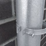 Detailansicht der verzinkten Fallrohrschelle, die ein Fallrohr an einer Ziegelwand befestigt