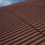 Detailansicht der Faserzement Wellplatten Europa Profil 5 rotbraun mit sichtbaren Wellen und Befestigungen