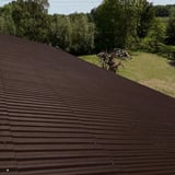 Schrägansicht einer grossen Dachfläche mit dunkelbraunen Faserzement Wellplatten Europa Profil 5