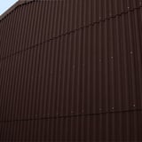 Fassade verkleidet mit dunkelbraunen Faserzement Wellplatten Europa Profil 5, vertikal montiert