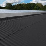 Dachfläche mit anthrazitschwarzen Faserzement Wellplatten Europa Profil 6 und sichtbaren Befestigungsschrauben
