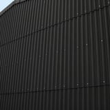 Fassade mit anthrazitschwarzen Faserzement Wellplatten Europa Profil 6, vertikal montiert