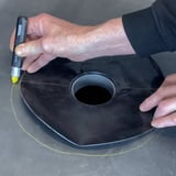 Garantie-Gully aus schwarzem EPDM, Hand markiert Kreis auf Dachbahn