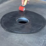 Garantie-Gully aus schwarzem EPDM, Verlegung, Hand rollt Gully mit Andruckrolle fest