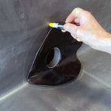 Hand markiert Umriss fuer Garantie-Seitenablauf auf EPDM-Dachbahn mit gelbem Stift