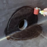 Installierter Garantie-Seitenablauf, mit Andrueckrolle wird die Verklebung optimiert
