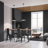 Esszimmer mit Holztisch, schwarzen Stühlen und dunklen Wänden, weisser Boden