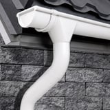 Reinweiße Dachrinne mit Konsolrinnenhalter und Fallrohr am Dach eines Hauses, Verlegung