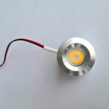 Detailansicht eines blanken LED Extra Spots aus Aluminium mit gelb leuchtendem Licht