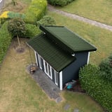 Anwendungsbeispiel: Kleines Gartenhaus mit Pultdach aus Chromoxidgrün (RAL 6020) Trapezblechen und Ortgangwinkel