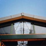 Ortgangwinkel aus Faserzement in Naturgrau am Giebel eines modernen Gebaeudes mit Glasfront