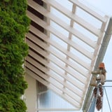 Verlegte PET Spundwandplatte klar 1,10 mm als Terrassendach mit Holzsparren und Dachrinne