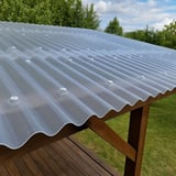 PET Wellrolle 76/18, klarbläulich, auf einem Holzunterstand montiert, mit Befestigungsschrauben