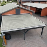 Verlegung von Pfannenblech Lichtgrau RAL 7035 auf einem Carport vor einem Ziegelhaus