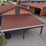 Pfannenblech 2/1060 rotbraun auf dem Dach eines Carports vor einem Ziegelhaus