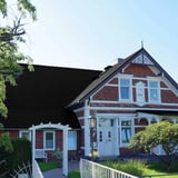 Pfannenblech Tiefschwarz RAL 9005 auf dem Dach eines historischen roten Backsteinhauses