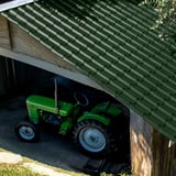 Verlegung des Pfannenblechs EUROPA in Moosgrün auf einem Carport-Dach, darunter ein Traktor