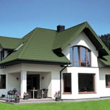 Verlegung des Pfannenblechs Szafir 350/15 Resedagrün auf einem modernen weissen Wohnhaus