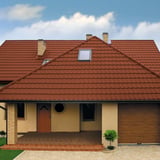 Ziegelrotes Pfannenblech Szafir 350/15 auf einem Wohnhaus mit Gaubenfenster