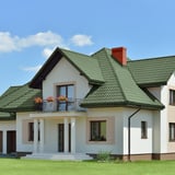 Pfannenblech Szafir 350/15, gruen, auf einem weissen Einfamilienhaus verlegt