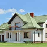Einfamilienhaus mit Dach aus Pfannenblech Szafir 350/15 in Resedagrün, weisse Fassade, Balkon