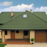 Vorderansicht eines Hauses mit Dach aus Pfannenblech Szafir 350/15 in Resedagrün, Dachfenster sichtbar
