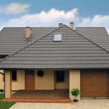 Haus mit Dach aus Pfannenblech Szafir 350/15 Graualuminium, mit Dachfenster und Schornsteinen