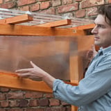 Polycarbonat Doppelstegplatte 6 mm klar wird von einem Mann auf einer Holzkonstruktion montiert
