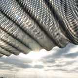 Unteransicht der Polycarbonat Wellplatte 76/18, bronze, mit Wabenstruktur und Sonnenlicht im Hintergrund