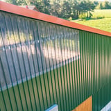 PVC Spundwandplatte klarbläulich als Lichtband in einer grünen Trapezblechwand verbaut, Anwendungsbeispiel