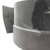 Detailansicht der Rolle des schwarzen EPDM Randfixierstreifens, glatte Oberseite und texturierte Unterseite