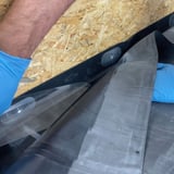 Montage des schwarzen EPDM Randfixierstreifens mit Befestigungselementen an einer Holzkonstruktion