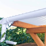 Regenwasserfänger PVC weiß, montiert an einer Dachrinne mit Regenfallrohr und Holzkonstruktion