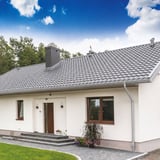 Haus mit Dachrinne und Rinnenablauf in Weißaluminium (RAL 9006) als Anwendungsbeispiel