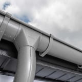 Rinnenablauf Graualuminium (RAL 9007) mit Wassertropfen am Dach, Detailansicht