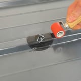 Hand rollt mit Andrückrolle einen schwarzen EPDM Schrauben Reparaturflicken fest