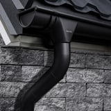 Stahl Dachrinne und Fallrohr in Tiefschwarz (RAL 9005) am Dach eines Hauses montiert, mit Niagara Logo