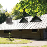 Dachansicht eines Hauses mit Stehfalzblech 33/500-LE in Graualuminium RAL 9007 und Gauben