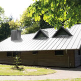 Stehfalzblech 33/500-LE in Weißaluminium RAL 9006 als Dach auf einem Wohnhaus mit Gauben