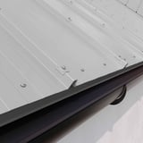 Detailansicht der Befestigung von Stehfalzblech 33/500-LR in Weißaluminium an einer Dachrinne