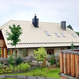 Stehfalzblech PD-510-S Flach, Reinweiß RAL 9010, auf einem Wohnhaus mit Gauben und Schornsteinen